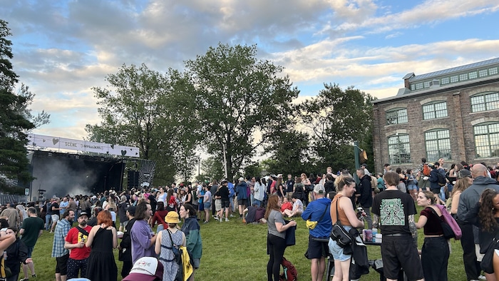 De nombreux festivaliers discutent dehors devant la scène en attendant le premier spectacle. 