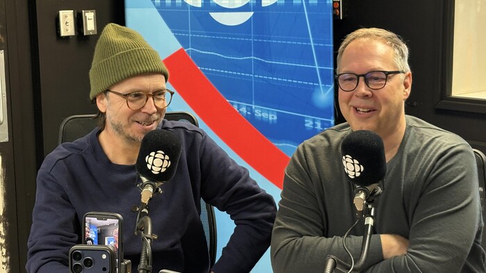 Deux hommes s'adressent au micro.