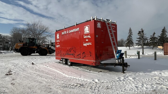 Boîte à Chanson du Festival du Voyageur à l'extérieur avec une tractopelle dernière.