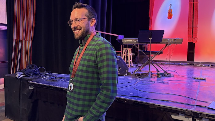 Kyle Burghout tout sourire avec sa médaille d'or fabriquée par une entreprise métis locale.