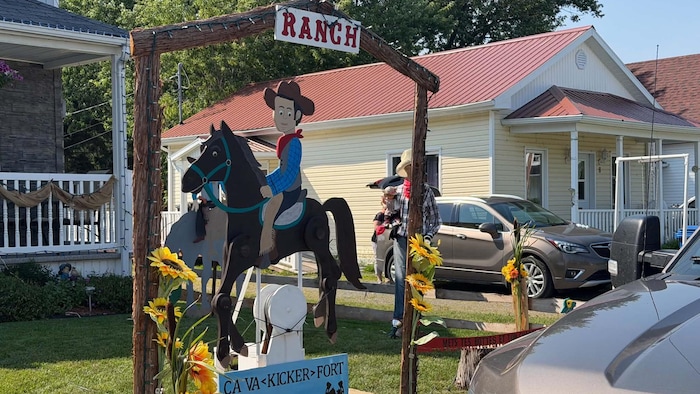 Des décorations sur un terrain de maison avec un cow-boy sur son cheval.