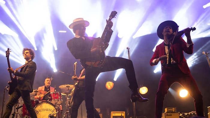 Jean-François Breau, Georges Belliveau et Kevin McIntyre jouent de la musique sur une scène. 