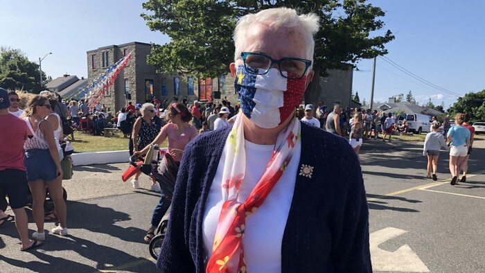 Brenda Murphy dans la rue portant un masque aux couleurs du drapeau de l'Acadie.