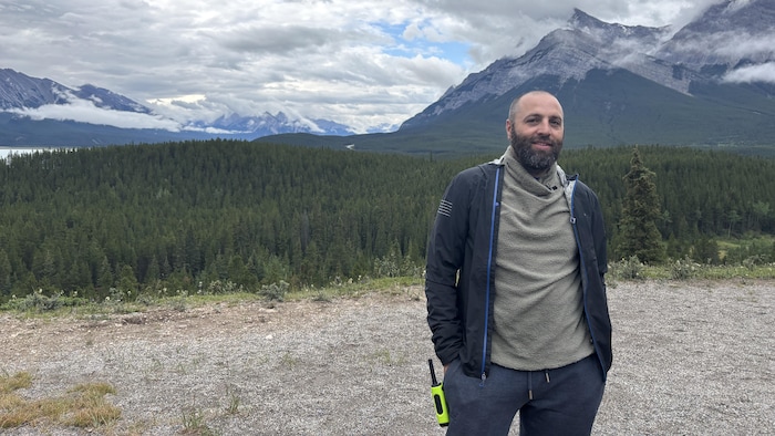 Romain Wojcieszek sourit devant les montagnes Rocheuses.