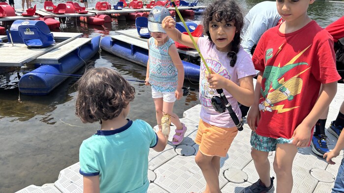 Ryem tient une canne à pêche au bout duquel pend une barbotte. 