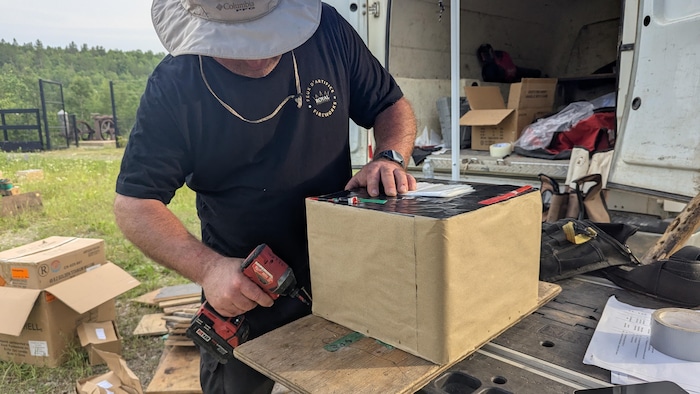 François Allen visse le bloc de feux d'artifice sur une plaque de bois.