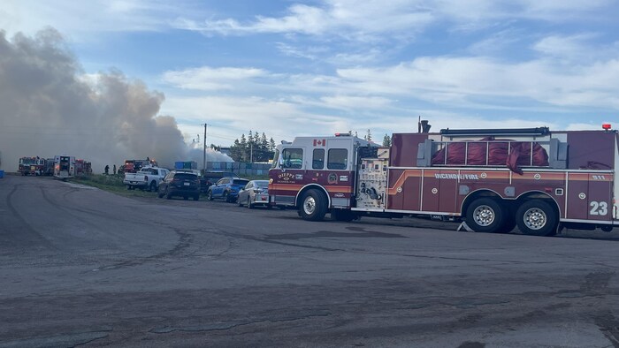 Un camion de pompiers et de la fumée au loin.