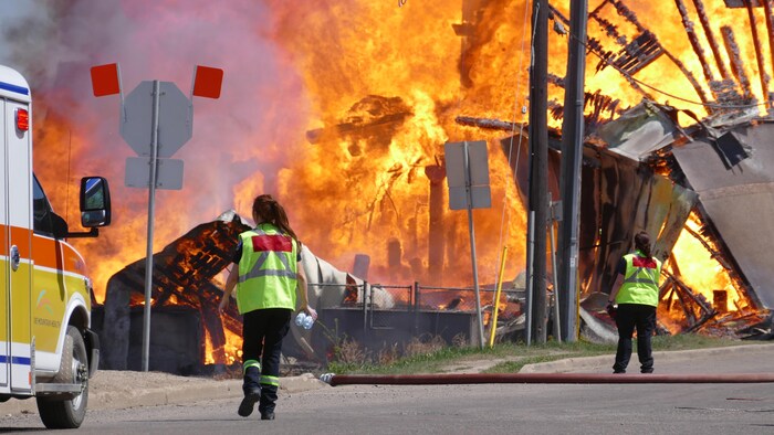 Des membres des services d'urgence marchent vers le brasier.