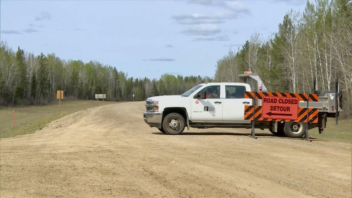 Une route est fermée près de Candle Lake, en Saskatchewan, en raison d'un feu de forêt, le 15 mai 2025.