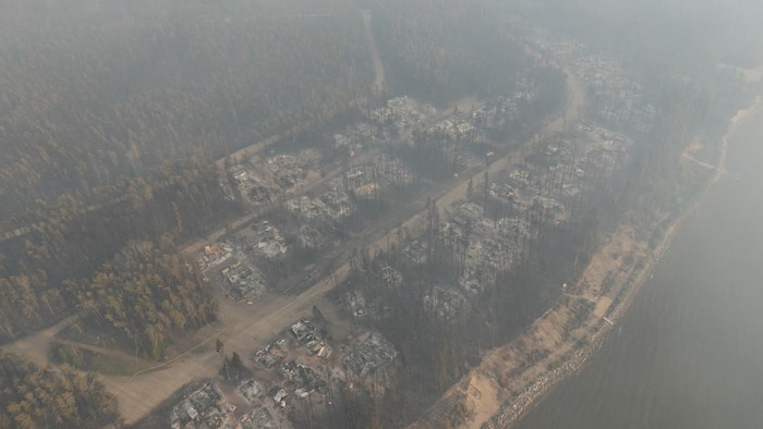 Des dizaines de chalets et de résidences d'East Trout Lake, en Saskatchewan, sont réduits en cendre après le passage d'un feu de forêt en mai 2025.