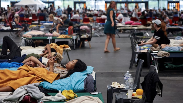 Des personnes déplacées par les feux de forêt en France sont hébergées  dans un refuge temporaire.