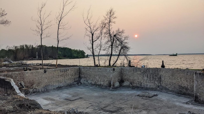 La fondation d'une maison, sous un coucher de soleil enfumé et rougeoyant.