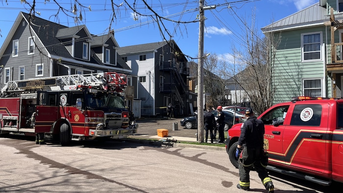 Des véhicules de pompiers sont stationnés dans la rue.