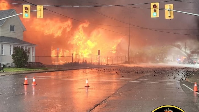Un feu avec de vives et féroces flammes consomme un bâtiment.