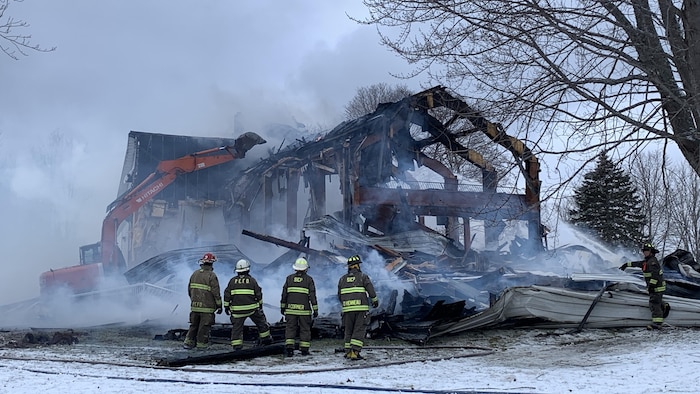 Décombres de l'église et pompiers.