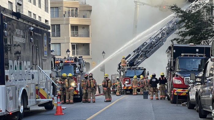 Des pompiers arrosent un immeuble.