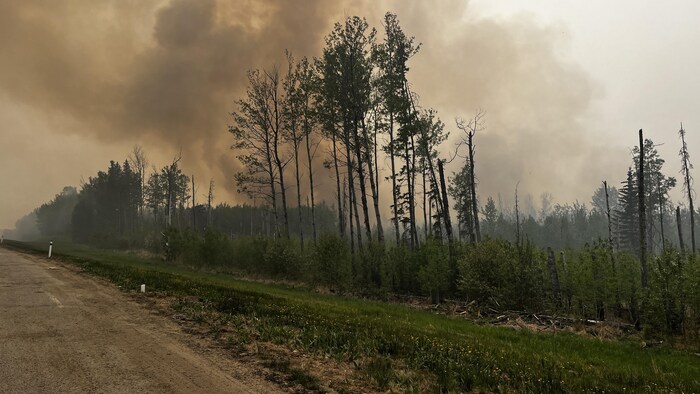 La route 33 près de Swan Hill, avec un feu de forêt et une fumée épaisse, en Alberta, le 21 mai 2023.