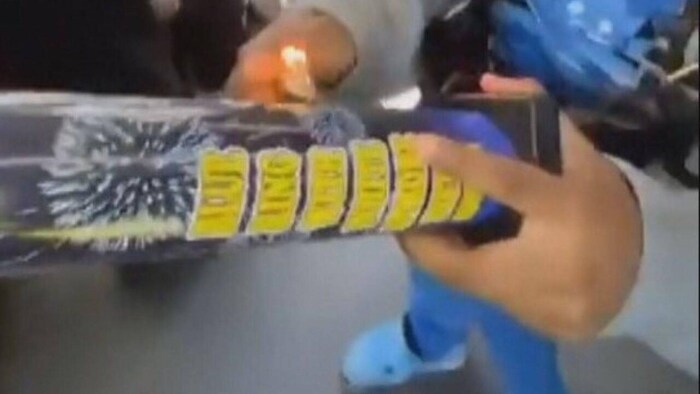 Une personne allume un feu d'artifice.