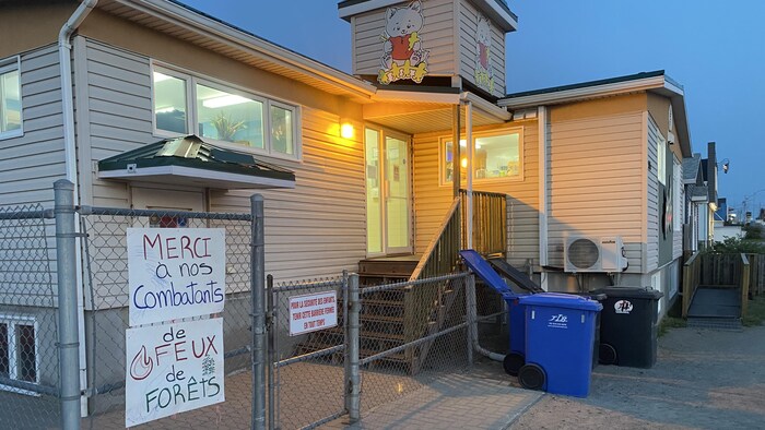 Des affiches disant «Merci à nos combatants de feux de forêts» sur la clôture d'une garderie.