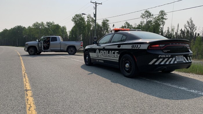 Une voiture de police de Lac-Simon près d'un camion sur la route.