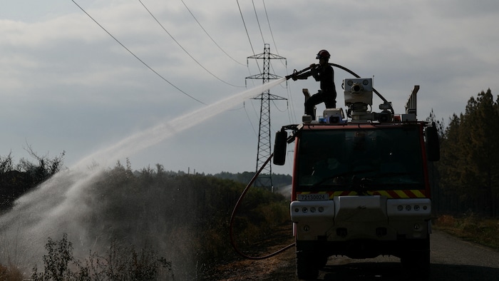 Un pompier français utilise une lance à eau lors des opérations de nettoyage, afin d’éteindre les derniers foyers d’incendie et les zones encore incandescentes.