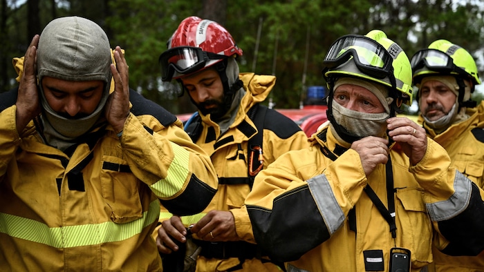 Des pompiers enfilent leur casque.