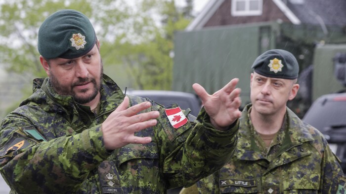 Un militaire en uniforme parle et fait un geste avec ses bras.