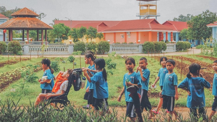 Des enfants au Vietnam jouent dans un champ. 