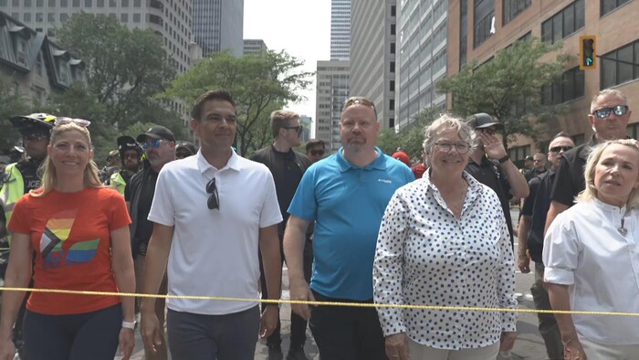 Des politiciens défilent dans le centre-ville sous escorte policière.