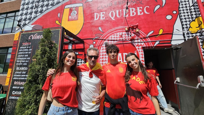 Quatre personnes arborent des maillots aux couleurs de l'équipe de l'Espagne.