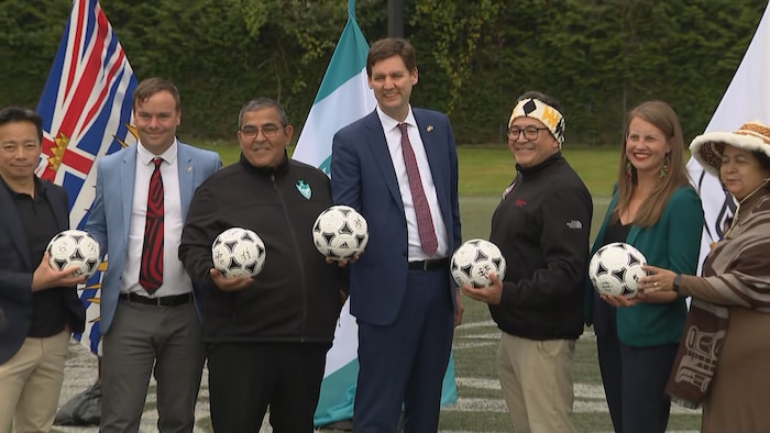 Les élus tiennent chacun un ballon de soccer.