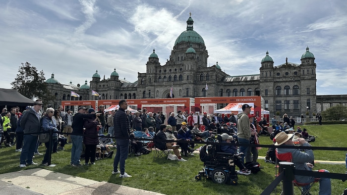 Des personnes devant l'Assemblée législative.