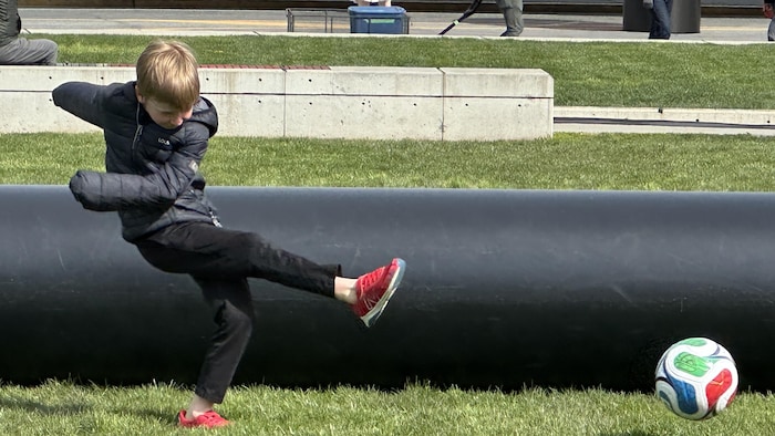 Un enfant joue au soccer.