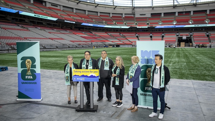 Le maire de Vancouver Ken Sim et des membres du gouvernement de la Colombie-Britannique dans le stade BC Place devant un lutrin, le 30 avril 2024.
