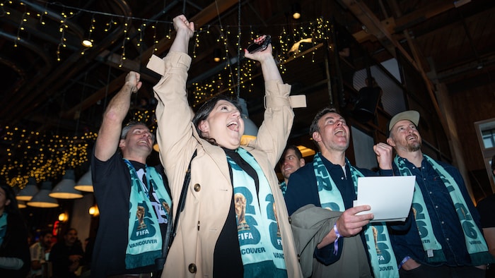 Des partisans applaudissent en regardant le tirage au sort du Canada lors d'un événement organisé à Vancouver, en Colombie-Britannique, le vendredi 5 décembre 2025.