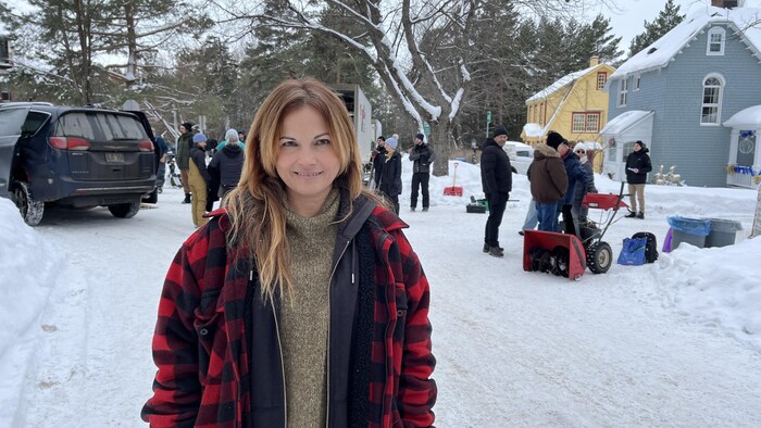 Josée Gagnon pose lors d'un tournage dans une rue en hiver.