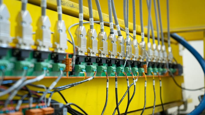 Des fils électriques branchés dans un panneau.