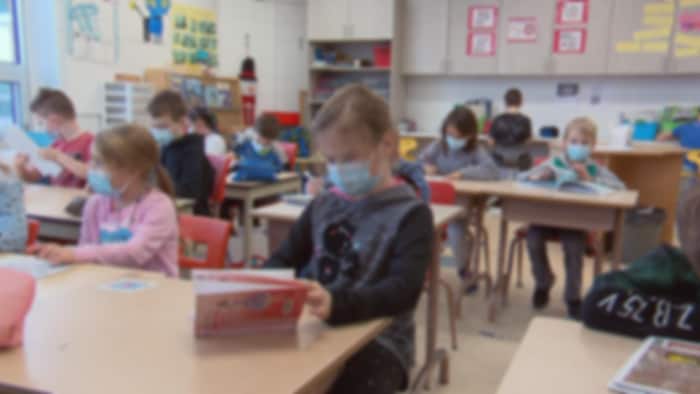Des élèves du primaire portent des masques sanitaires dans une classe.