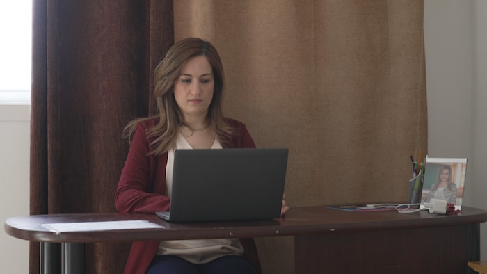 Imane Benchouk est dans un local devant son ordinateur.