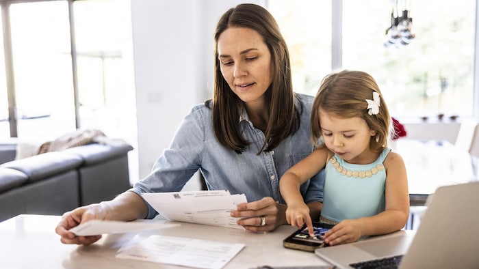 Une femme travaille à ses finances personnelles avec sa fille.