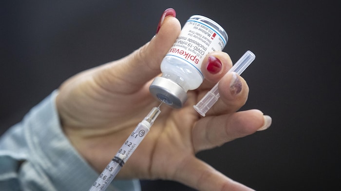 Une seringue insérée dans une fiole de vaccin.
