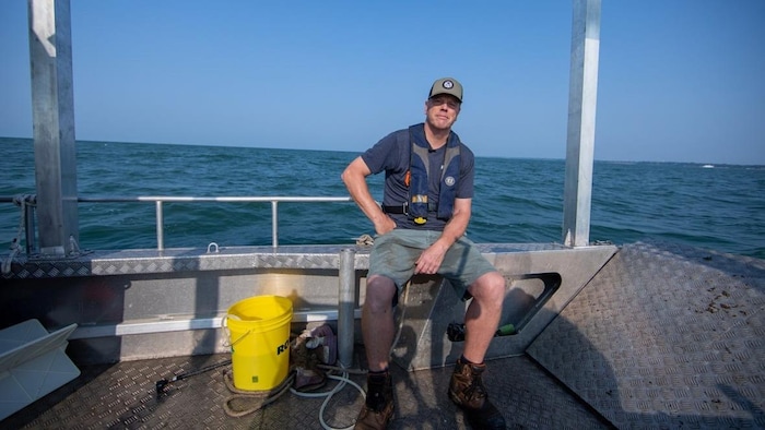 Aaron Fisk assis dans un bateau