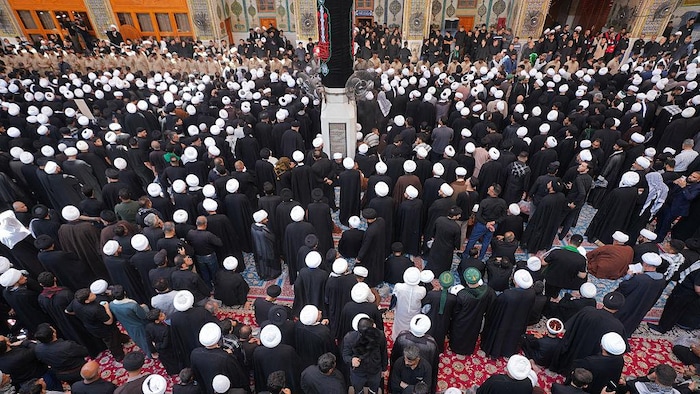 Une foule rassemblée lors d'une cérémonie funéraire publique.
