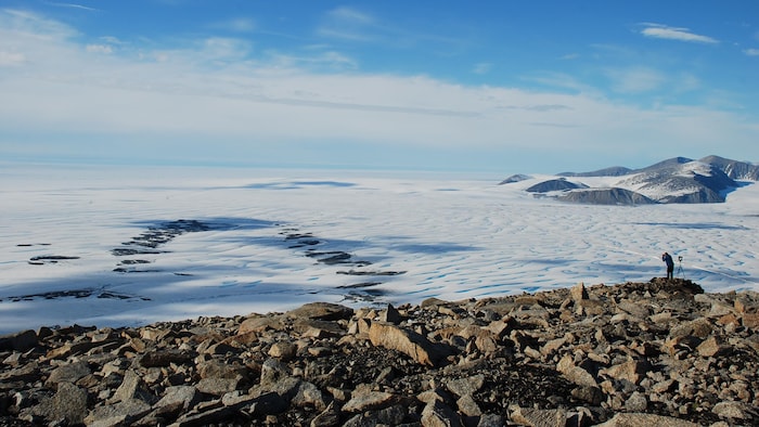 Une personne prend en photo un paysage de glace.