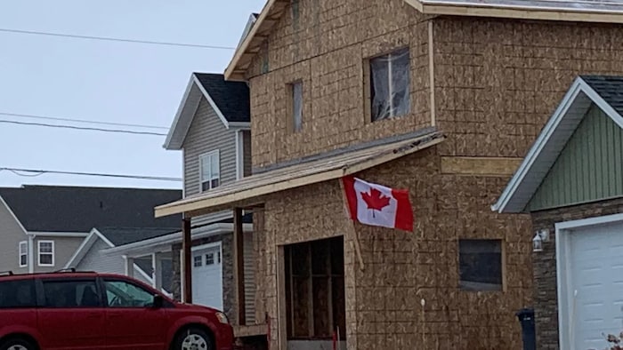 A Canadian flag flies on their new home under construction. 