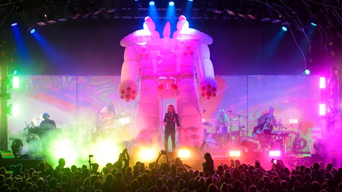 Les Flaming Lips jouent sur un scène sur laquelle est érigé un grand robot gonflable.