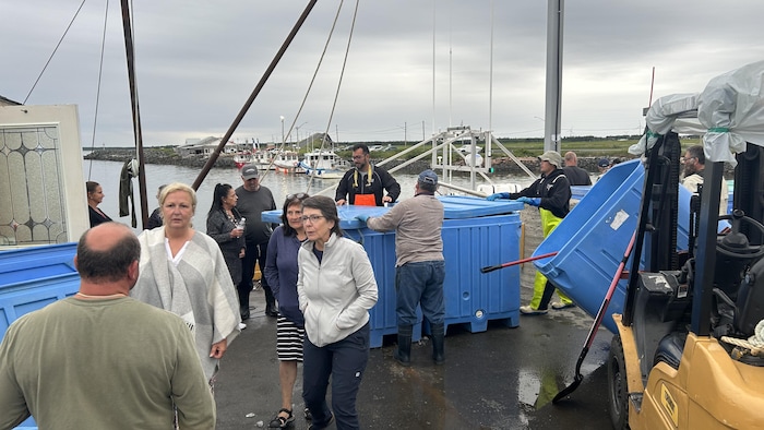 Des gens discutent sur un quai.