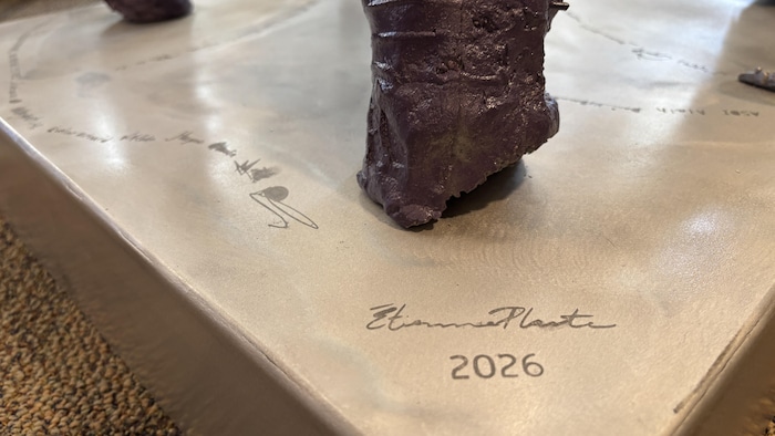 La signature des artistes sur le pied de la fleur.