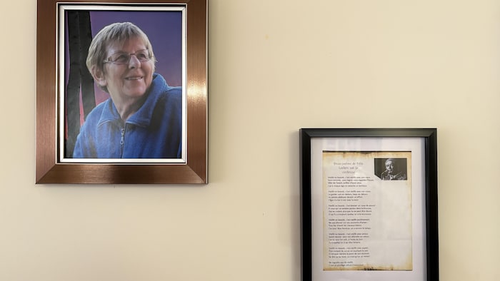 Un portrait de Fleurette Beauparlant accroché sur un mur, près d'un poème de Félix Leclerc.
