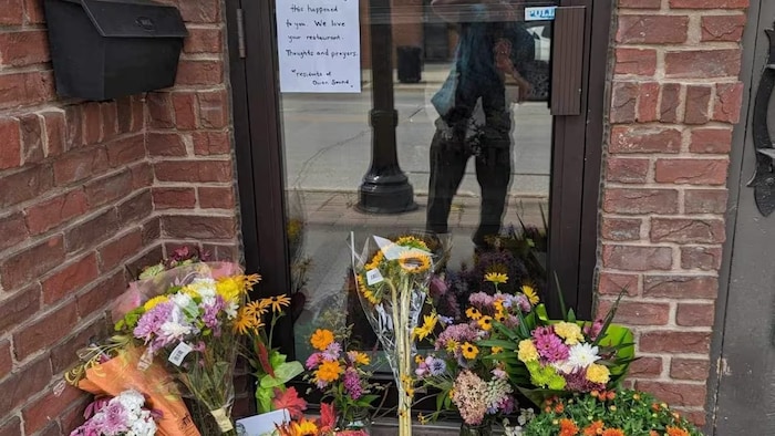 Des fleurs et des messages sont déposés devant le restaurant.